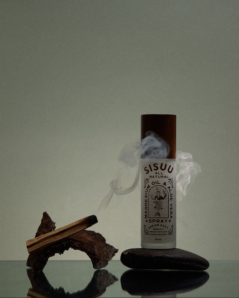 SISUU natural oil spray bottle on a reflective surface with a neutral background